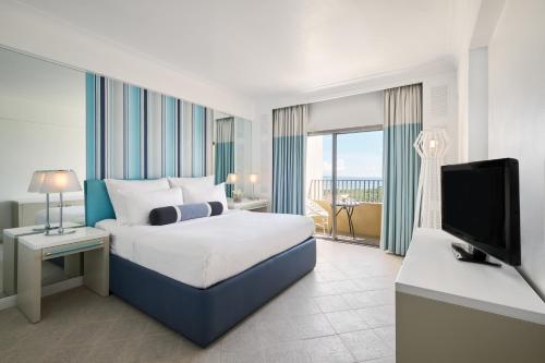 a hotel room with a bed and a television at Mövenpick Hotel Mactan Island Cebu in Mactan