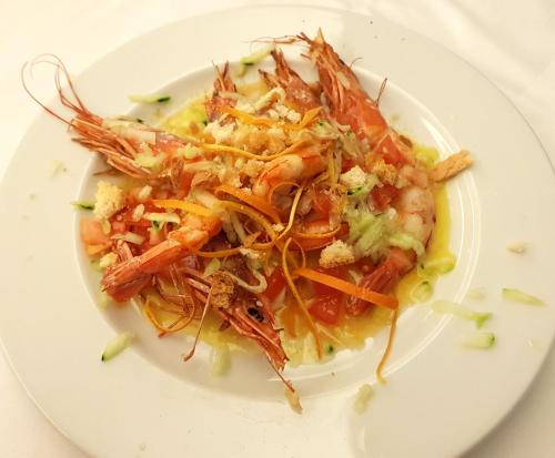 a plate of food with shrimp on a white plate at Hotel Bristol in Lignano Sabbiadoro