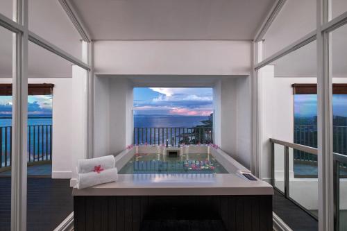 a balcony with a hot tub with a view of the ocean at Mövenpick Hotel Mactan Island Cebu in Mactan