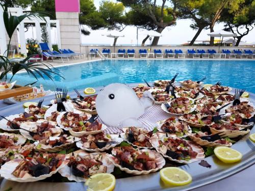 a tray of food on a table next to a pool at Hotel Bristol in Lignano Sabbiadoro
