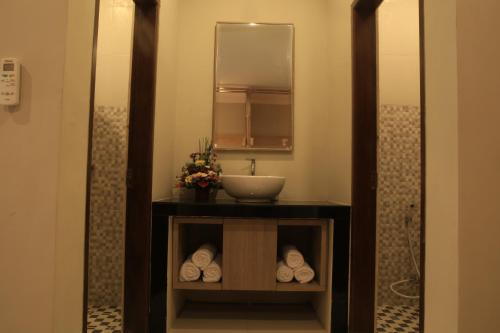 a bathroom with a sink and a mirror at Poshtel Ubud in Ubud