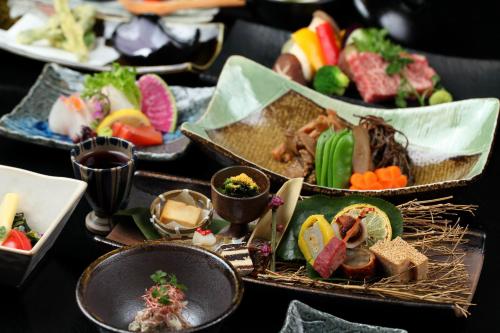 une table recouverte de différents types de nourriture dans des plateaux dans l'établissement Kurokawa Onsen Yama no Yado Shinmeikan, à Minamioguni