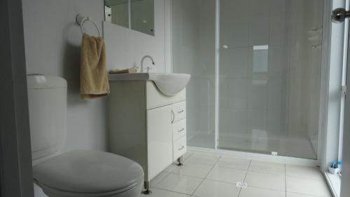 a bathroom with a shower and a toilet and a sink at Kangaroo Island Bayview Villas in Kingscote