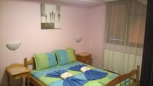 a small bedroom with a bed with blue and green sheets at Villa Bulgarka in Divchovoto