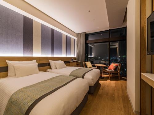 En eller flere senge i et værelse på JR Kyushu Hotel Blossom Naha