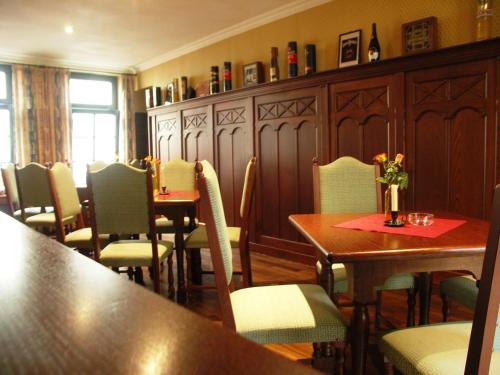 a dining room with wooden tables and chairs and a table and chairsktop at Hotel & Restaurant Klosterhof in Dresden