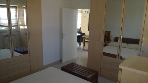 a room with a bedroom with a bed and mirrors at Apartment Vjera in Punat