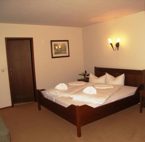 a bedroom with a large bed with white sheets and pillows at Hotel & Restaurant Klosterhof in Dresden