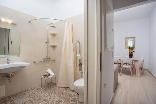 a bathroom with a sink and a toilet and a table at Villa Evilia in Márpissa