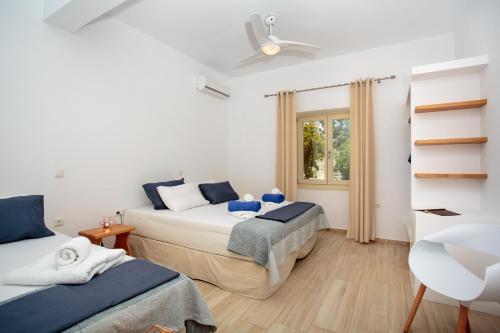 a bedroom with two beds and a window at Villa Evilia in Márpissa