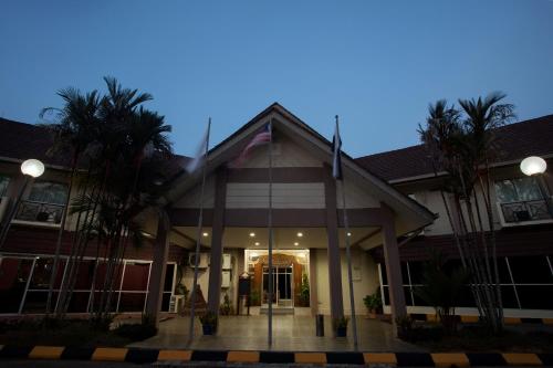 a building with palm trees in front of it at Hotel Seri Malaysia Temerloh in Temerloh