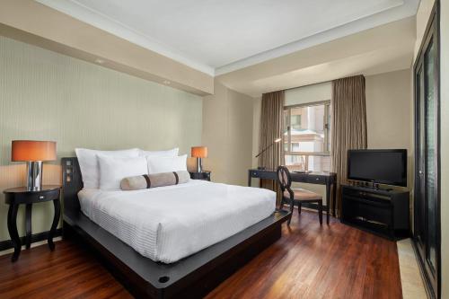 a hotel room with a bed and a television at Mövenpick Hotel Mactan Island Cebu in Mactan