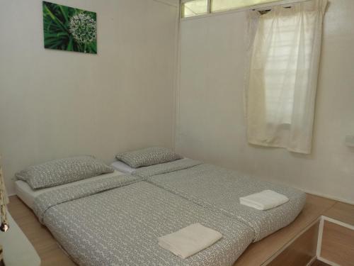 a bedroom with a bed with two pillows and a window at Moonriver Lodge in Cameron Highlands