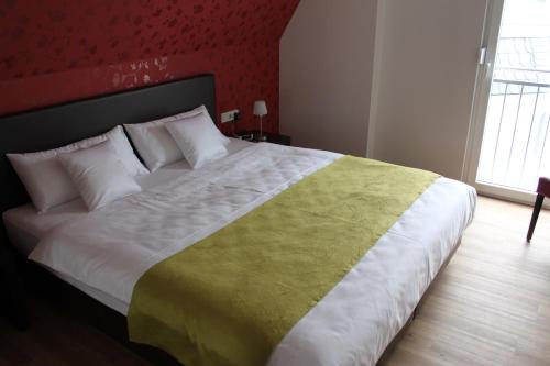 a bedroom with a large bed with a green and white blanket at Feriendomizil am Lindenplatz in Bullay