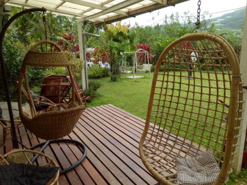 a porch with two swinging chairs on a wooden deck at Moonriver Lodge in Cameron Highlands