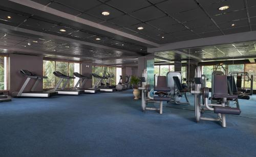 a gym with treadmills and chairs in a room at Mövenpick Hotel Mactan Island Cebu in Mactan