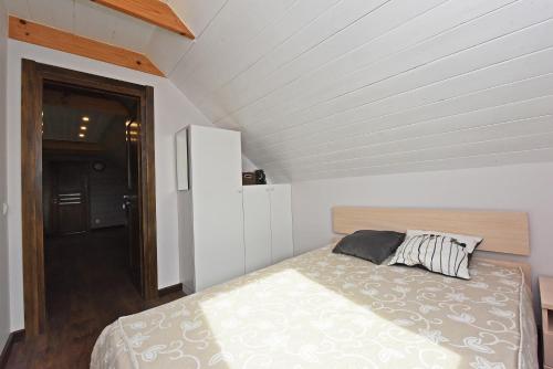 een slaapkamer met een bed op zolder bij Villa Ievynė in Paežeriai