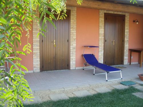 a blue chair sitting on the porch of a house at Agriturismo Il Borgo Degli Ulivi in Roseto degli Abruzzi