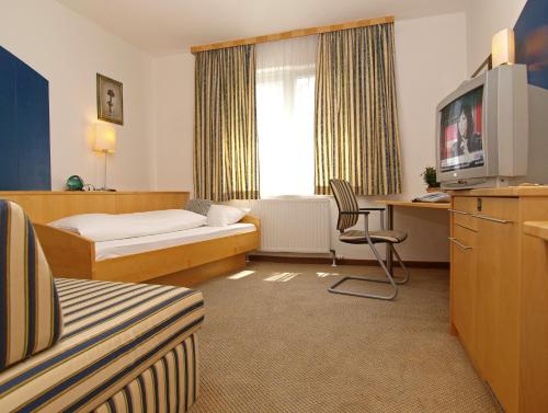 a hotel room with a bed and a tv at Gastwirtschaft & Hotel Holzinger in Möllersdorf