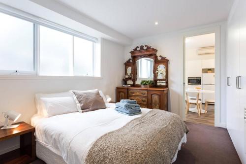 a bedroom with a bed and a table and a mirror at Your Home Away from Home in Melbourne