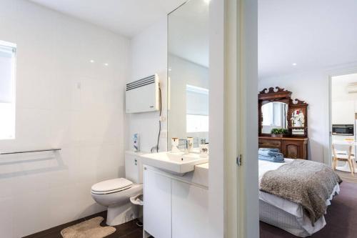 a white bathroom with a toilet and a sink at Your Home Away from Home in Melbourne