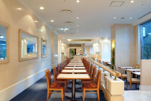 a long row of tables and chairs in a restaurant at Narita Gateway Hotel in Narita