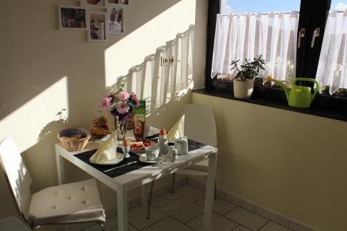 バッハラッハにあるFerienwohnung SONNENUHRの窓付きの客室で、白いテーブルと椅子が備わります。