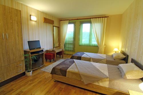 a hotel room with two beds and a television at Hotel Asenevtsi in Veliko Tŭrnovo