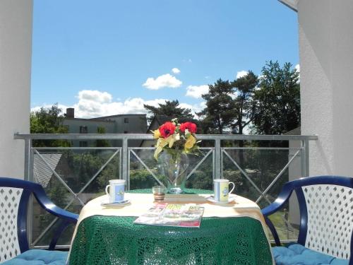 einen Tisch mit einer Blumenvase auf dem Balkon in der Unterkunft Ferienwohnung 1 3 18 Inselstrand in Ahlbeck