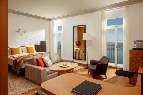 a hotel room with a bed and a living room at Bürgenstock Hotels & Resort - Palace Hotel in Bürgenstock