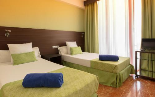 a hotel room with two beds and a television at Magic Tropical Splash in Cala de Finestrat