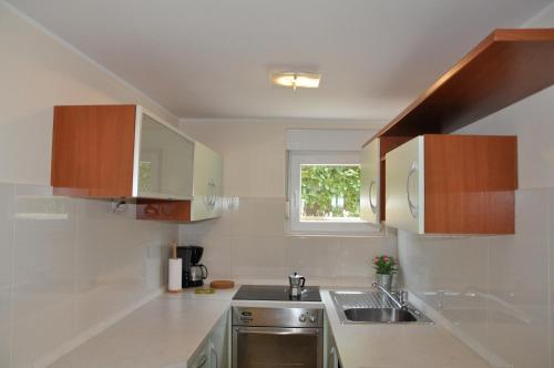 een kleine keuken met een wastafel en een raam bij Apartments Ulivo in Poreč