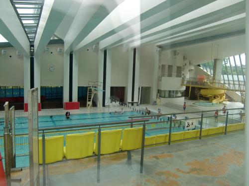 a swimming pool with yellow chairs in a large room at Guest house Kotone KYOTO in Kyoto