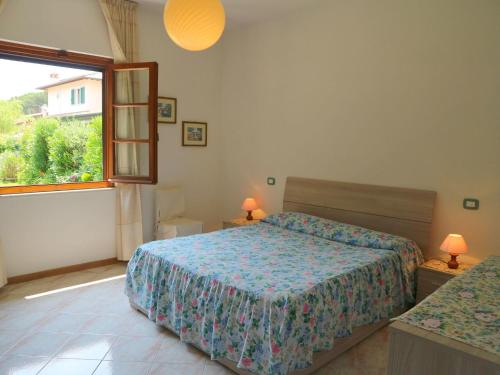 a bedroom with a bed and a mirror and a window at Bungalow near beach with covered terrace at Tuscan Coast in Massa
