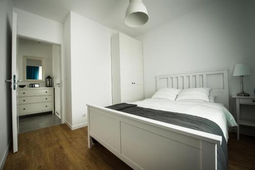 1 dormitorio blanco con 1 cama grande y vestidor en Apartament w Piszu, en Pisz