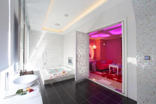 a bathroom with a tub and a sink and a bath tub at Affair motel Co.Ltd in Wuqi