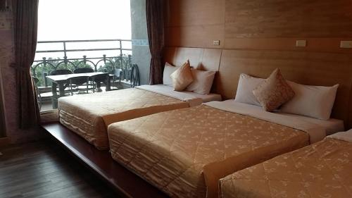 2 bedden in een hotelkamer met een balkon bij Hua Hung Guest House in Eluan