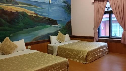 鵝鑾的住宿－華宏海景旅店 ，墙上画画的房间里设有两张床