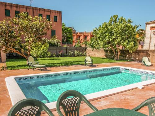 een zwembad met stoelen naast een gebouw bij Belvilla by OYO Can Bertu in Sant Pere Pescador