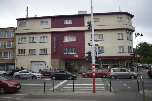 un gran edificio con coches estacionados en un estacionamiento en Hotel Prince de Liege en Bruselas