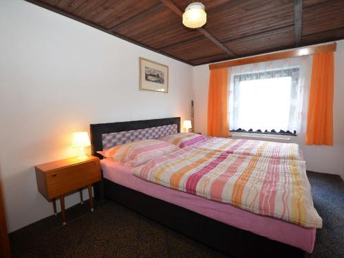 a bedroom with a bed and a window and a nightstand at Country House in Czech Forest with Pool in Konstantinovy Lázně