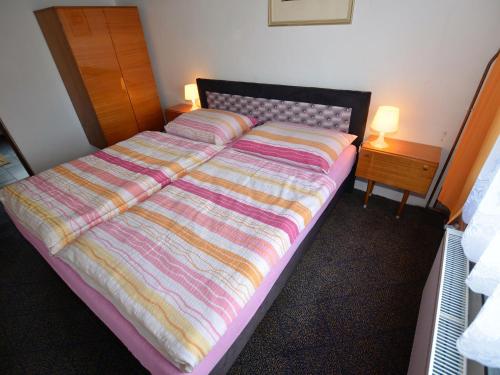 a bed with a colorful comforter in a bedroom at Country House in Czech Forest with Pool in Konstantinovy Lázně