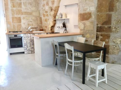 une cuisine avec une table et des chaises noires ainsi qu'un comptoir dans l'établissement La petite maison d’à côté, au n°11, à Saint-Aignan