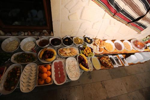 une table remplie de nombreux types d'aliments différents dans l'établissement Peace Stone House, à Gorëme