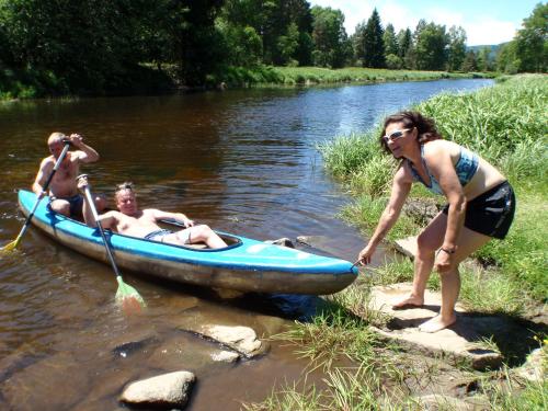 a man and a woman in a boat on a river at Ubytování Lyžařská škola in Kubova Huť