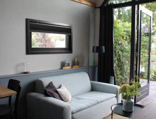 a living room with a couch and a window at Hoeve Altena Guesthouse in Woudrichem