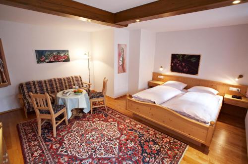 a bedroom with a bed and a table and a chair at Hotel Oberschmied in Reit im Winkl