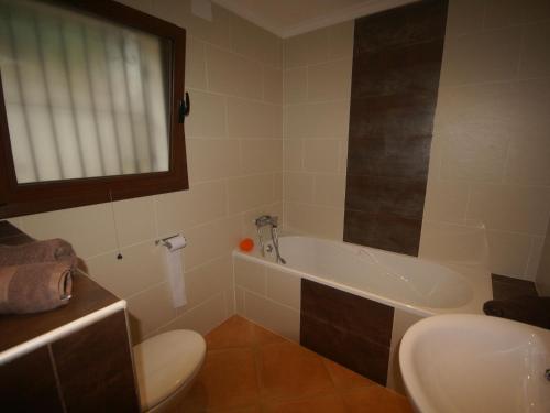a bathroom with a tub and a toilet and a sink at Nice villa in Moraira with private pool and lots of privacy in Moraira