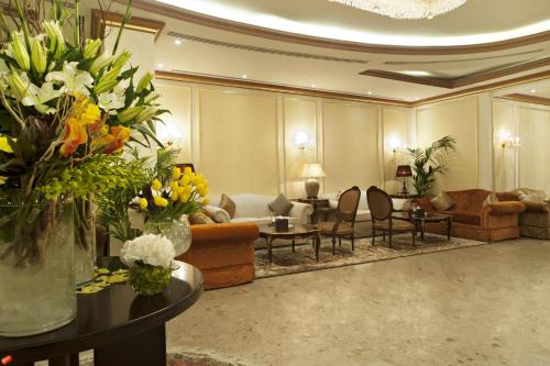 a living room filled with furniture and flowers at Magnum Hotel & Suites West Bay in Doha