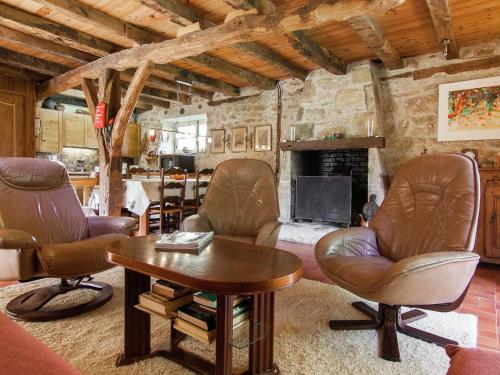 a living room with leather chairs and a fireplace at Farmhouse in Saint Cybranet with Private Garden in Saint-Cybranet